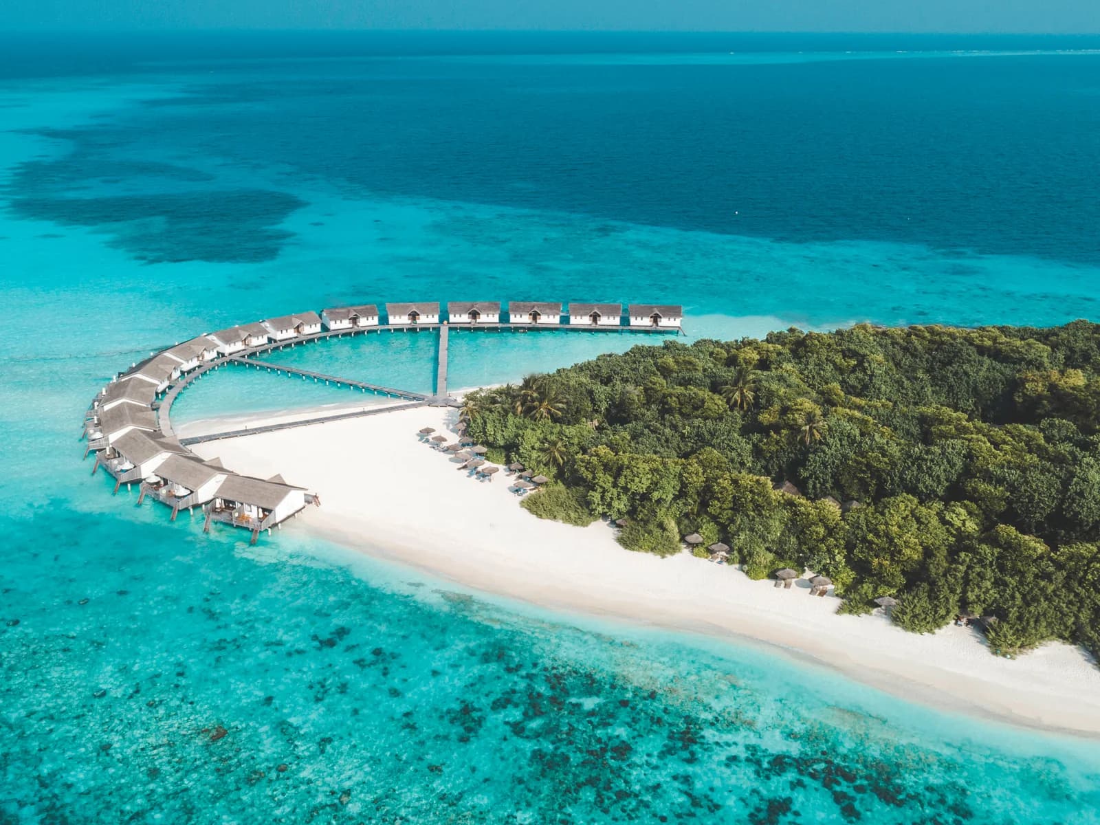 Overwater villas and beach at NH Collection Maldives Reethi Resort