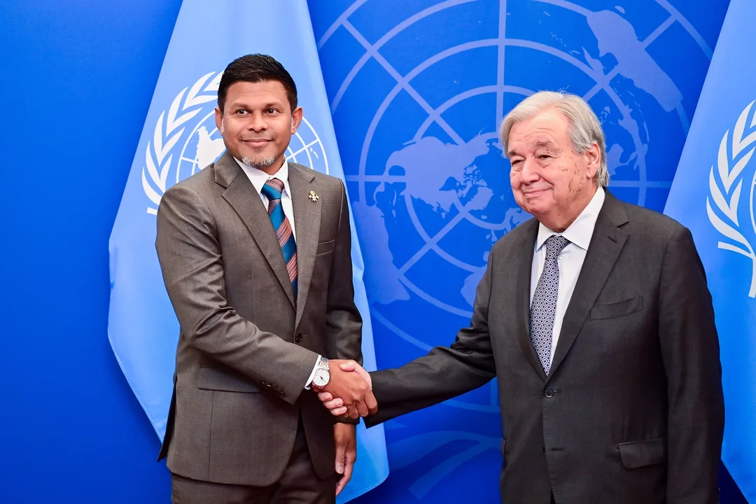 Vice President Hussain Mohamed Latheef shakes hands with UN Secretary-General António Guterres in front of United Nations flags.